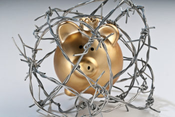 Golden piggy bank secured with barbed wire.